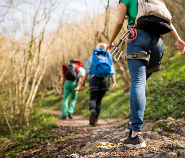 Women with day packs and climbing gear hiking on a trail