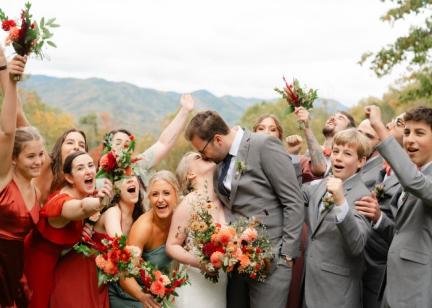 Newlyweds celebrate with family and friends against a Blue Ridge Mountain backdrop. 