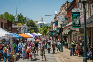 People on the street with the historic courthouse and mountains behind