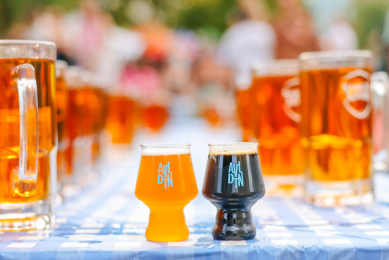 Beer steins lined up on a Bavarian style table cloth