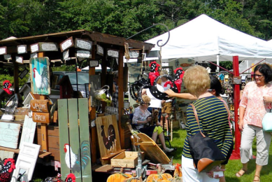 People perusing handmade art at an outdoor festival