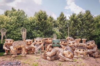 A group of trolls by Thomas Dambo, made from reclaimed wood and natural materials, lined up in a group.
