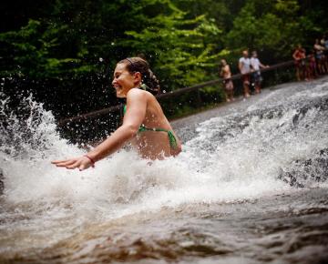 Girl sliding on Sliding Rock in Brevard NC