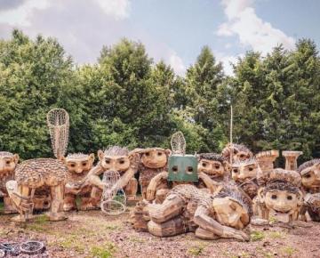 A group of trolls by Thomas Dambo, made from reclaimed wood and natural materials, lined up in a group.