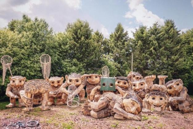 A group of trolls by Thomas Dambo, made from reclaimed wood and natural materials, lined up in a group.